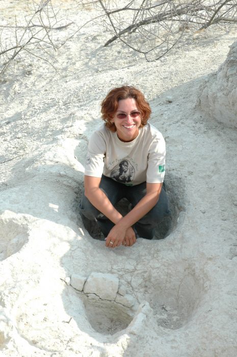 Pobiner sits in a fossilized footprint