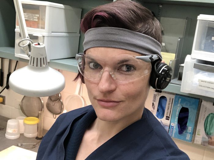 Head shot of holder looking intense, wearing headband and safety glasses