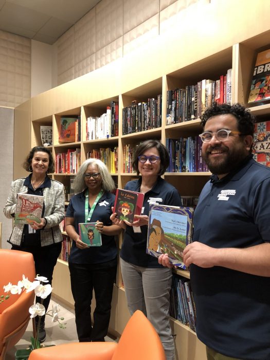 Smiling volunteers holding children's books