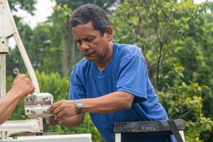 Raúl Ríos adjusting equipment in the field