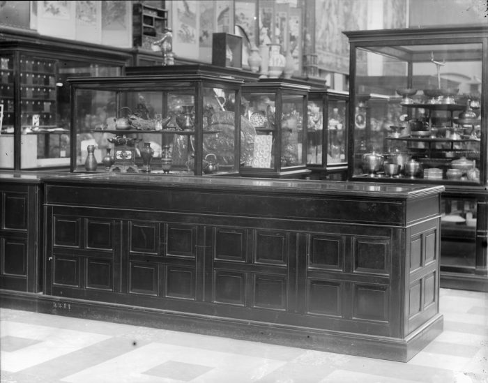 Black and white photo of glass cases displaying objects at A&I building