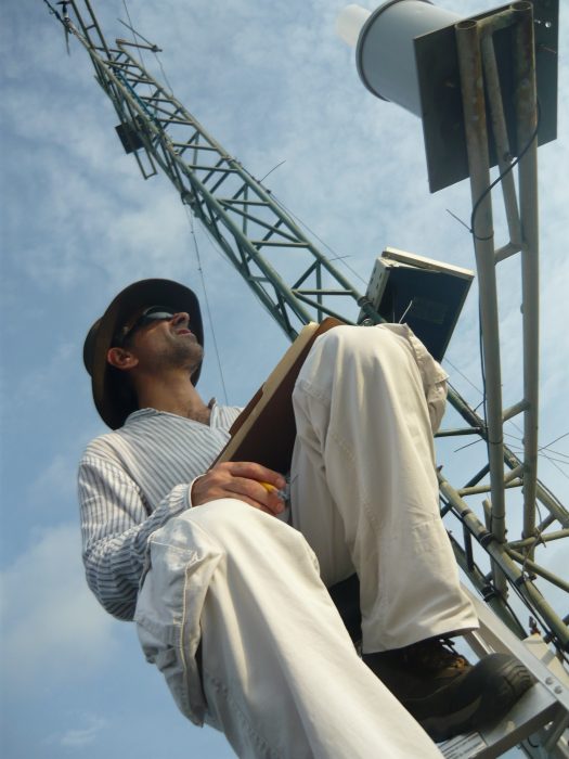 Sergio Dos Santos recording data while on a radio tower