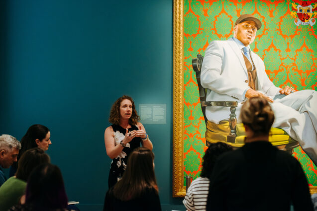 Briana White speaks to students in front of portrait of Kanye West by Kahinde Wiley