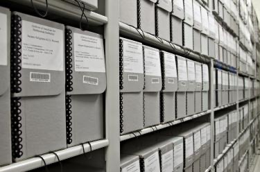 Black and white photo of shelves of archival boxes