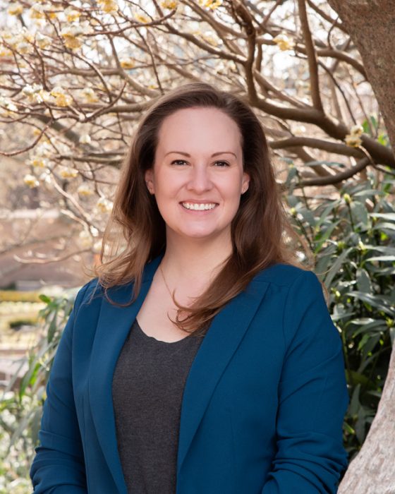 Head shot of Alexis Miller photographed against background of tulip magnolias