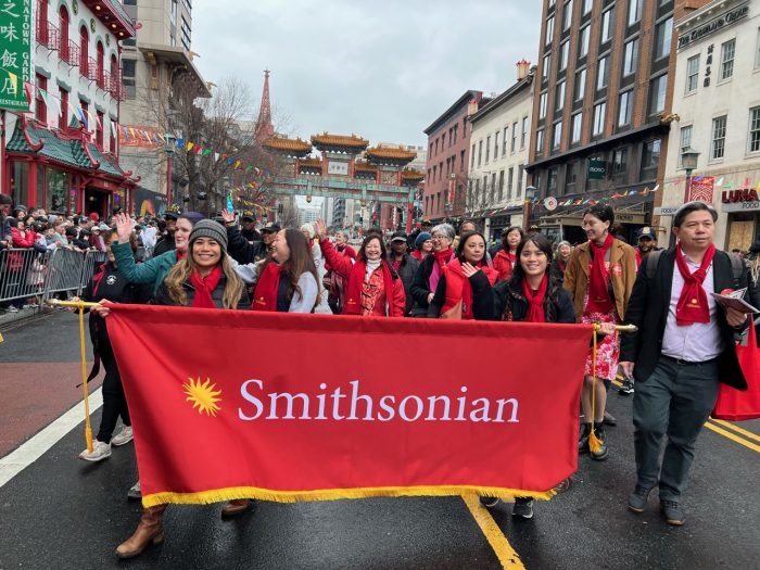 Parade participants holding red Smithsonian banner at Lunar New Year parade