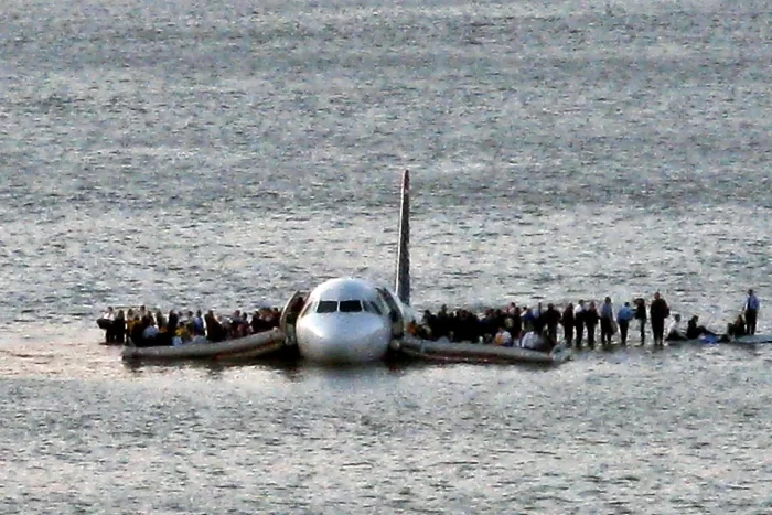 US Airways Flight 1549 in the water with passengers standing on its wings