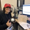 DeCorleto, wearing red ball cap displays her medal for 50 years of service