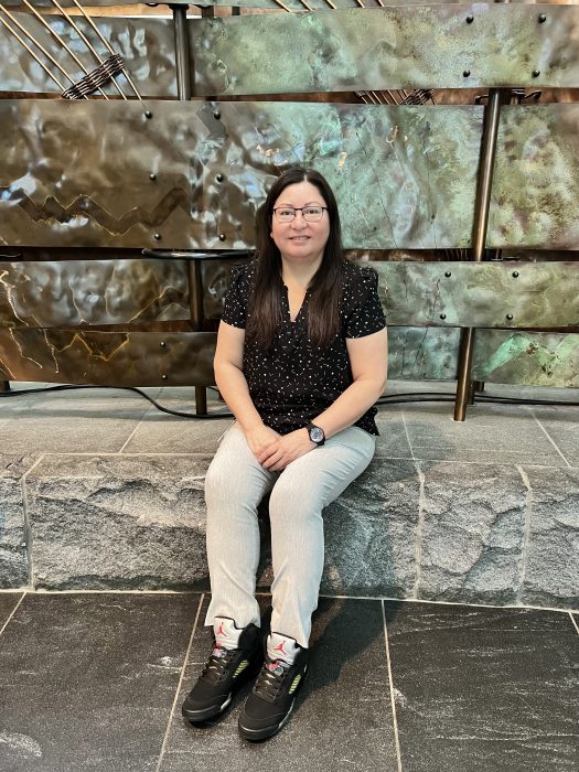 Adrienne Smith sitting on wall at the National Museum of the American Indian