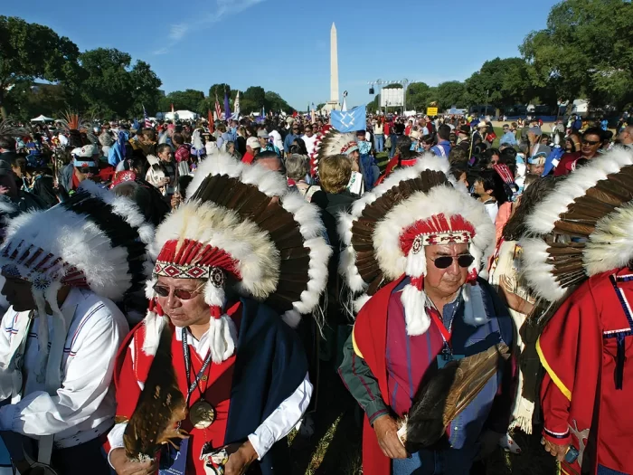 Throngs of Native Americans, many in traditional headgear, on the Mall with the Washington Monument in the background