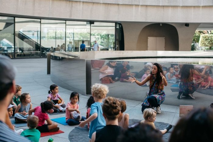 Children listening to a storyteller at HMSG