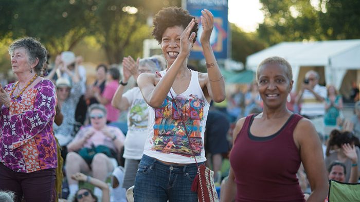 Visitors to the Folklife Festival clap their hands in time to a musical performance