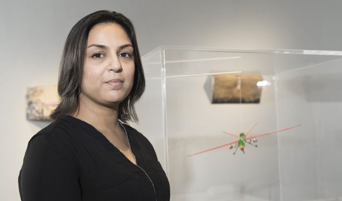 Portrait of Chistry standing in front of gallery installation