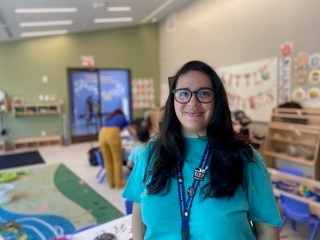 Laura Hernandez smiles for the camera while standing in the Bird House playroom