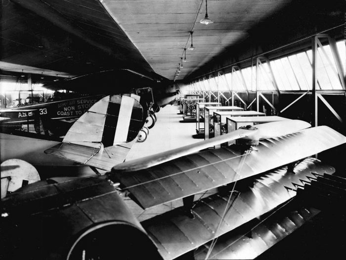 B&W photo of aircraft stored in a quonset hut hangar