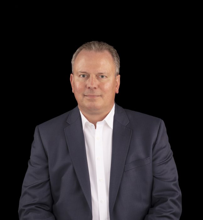 Portrait of Burba in grey jacket and white shirt against black background