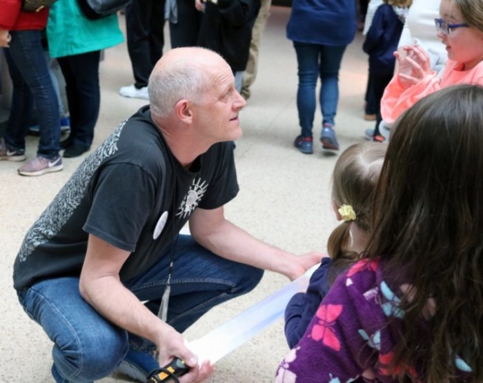 Collins squarring down to talk with visiting children