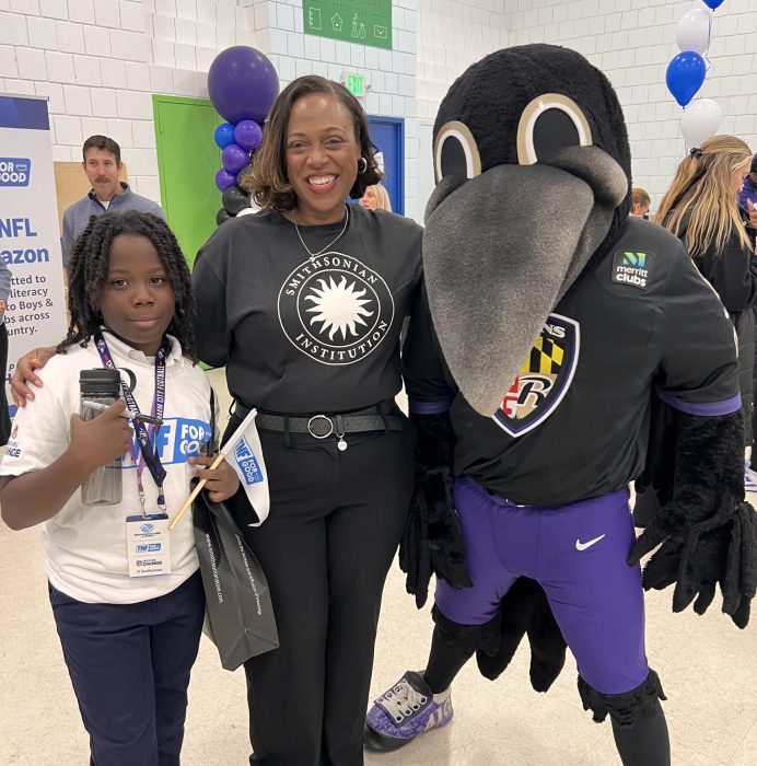 Monique Chism with Baltimore Ravens mascot and child at Bpys & Girls Club Event