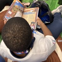 A young boy reads from a book about the American History Museum