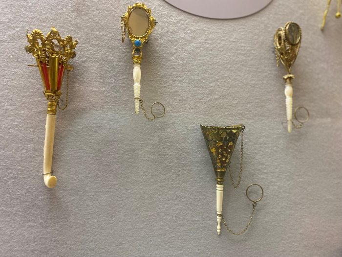 Four silver and ivory bouquet holders in display case