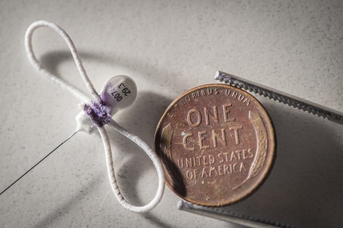 Close up of tiny radio ytag next to a penny for scale.