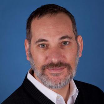 Headshot of Paul Gardullo against blue background
