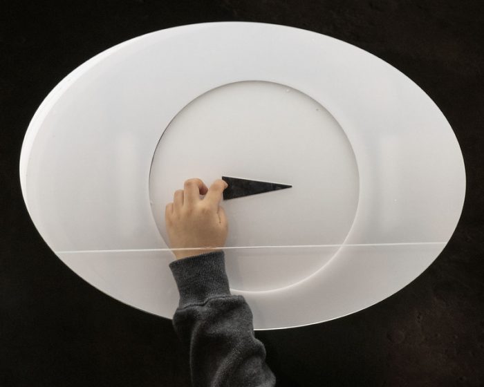 Dark triangular slice of moon rock inside a white oval display panel