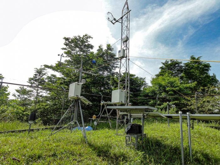 A complicated structure composed of scaffolding and measuring instruments in a grassy field