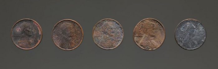 Row of penny coins showing fire damage