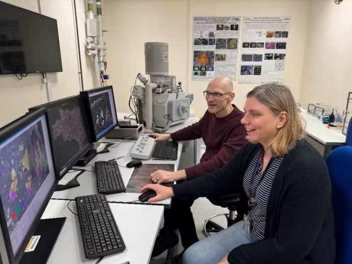 Russell and Salge seated at computer table looking at different monitors