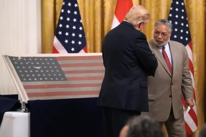 Hetty image of Lonnie Bunch shaking hands with Donal Trump (back to camera)