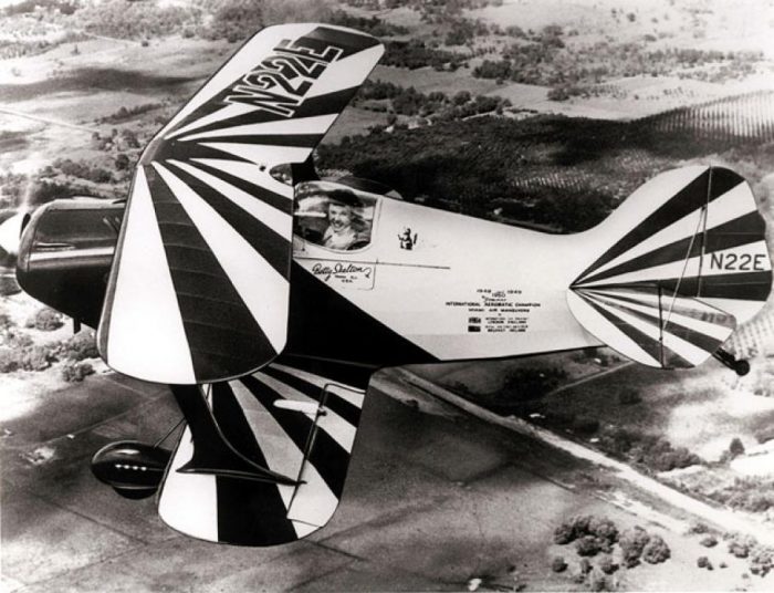 Black and white close-up aerial shot of Skelton piloting small biplane