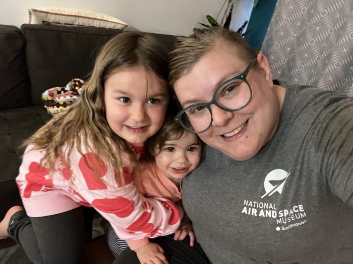 Baldioli wearing NASM sweatshirt takes a selfie with two young girls
