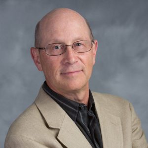 Head shot of Mark Reid against a gray background