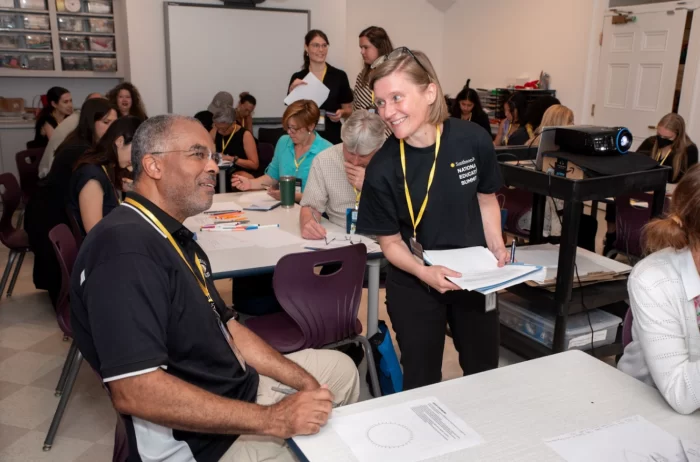 Volunteers wearing black National Education Summit T shirts pass out materials