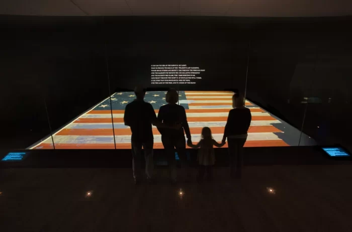 Star-Spangled Banner on display at NMAH; family silhouetted in foregound